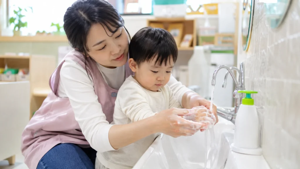 Korean-daycare-teacher-toddler-handwashing-with-soap-and-running-water